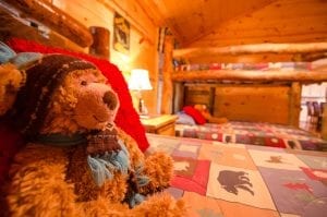 Deer Ridge cabin teddy bear on a bed