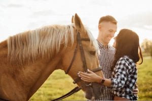 Photo of a Couple Petting a Horse near One of Our Broken Bow Honeymoon Cabins.