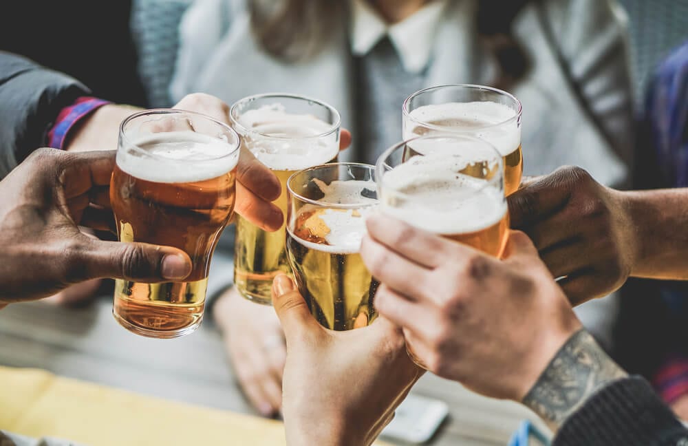 Friends clinking their pints at a Broken Bow Brewery