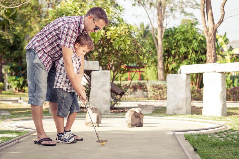 A father and son playing mini golf in Broken Bow