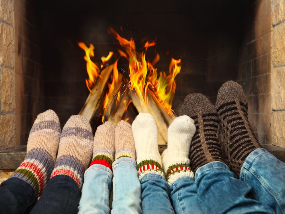 A family warming their feet by the fireplace on a winter day in Broken Bow, Oklahoma