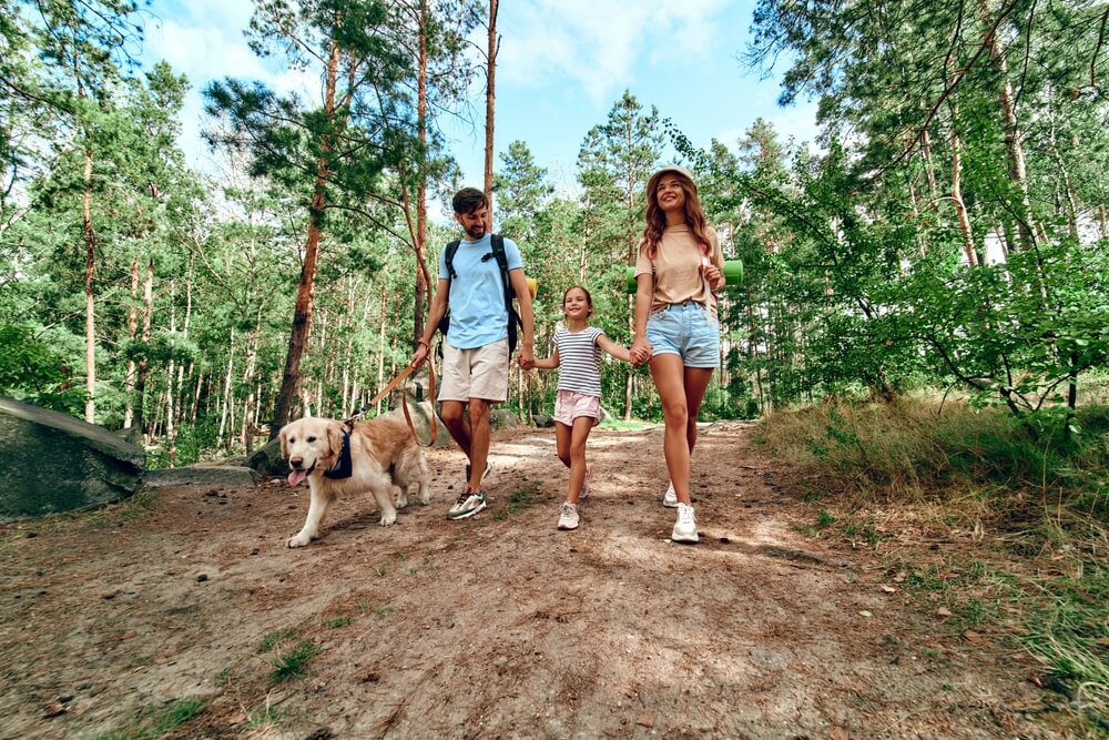 A family with a dog on a hike in the Oklahoma forest during spring break