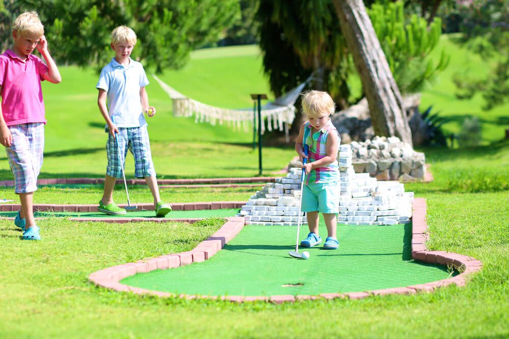A family playing mini golf in Broken Bow