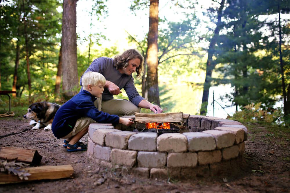 A father and son building a fire during spring break in Broken Bow, Oklahoma